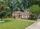 Classic brick home features lush green lawn, a charming walkway, and mature trees surrounding the property at 1024 Regency Dr, Charlotte, NC 28211