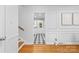 Bright hallway with hardwood floors, paneled walls, and doorway views to a stylish kitchen beyond at 1024 Regency Dr, Charlotte, NC 28211