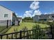 Fenced backyard with lush green grass and a view of neighboring houses under a beautiful sky at 11031 Larkslea Ln, Charlotte, NC 28278