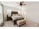 Well-lit bedroom with ceiling fan, decorative bed, and neutral tones creating a serene atmosphere at 11031 Larkslea Ln, Charlotte, NC 28278