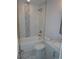 Bright bathroom featuring a tub with shower, marble flooring, gray vanity, and marble tile at 258 Lincoln Sw St, Concord, NC 28025