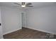 Bedroom featuring modern flooring, neutral walls, ceiling fan, and a door to hallway at 258 Lincoln Sw St, Concord, NC 28025