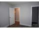 Bedroom showcasing neutral walls, wood flooring, and open doorways to other rooms at 258 Lincoln Sw St, Concord, NC 28025