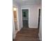 Bright hallway featuring modern wood flooring, white trim, and doors to bathroom and bedroom at 258 Lincoln Sw St, Concord, NC 28025