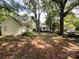 Spacious backyard with mature trees and a view of the shed and the house's back exterior at 310 E Houston St, Monroe, NC 28112