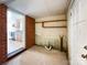 Unfinished basement space with brick wall, shelving, exposed pipes and access to kitchen at 310 E Houston St, Monroe, NC 28112