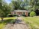 Charming brick home featuring a well-manicured front yard and inviting walkway at 310 E Houston St, Monroe, NC 28112
