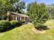 Charming brick home with manicured front lawn, complimented by green shrubs and a mature tree at 310 E Houston St, Monroe, NC 28112