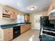 Cozy kitchen featuring light wood cabinetry, a black appliance package and a window over the sink at 310 E Houston St, Monroe, NC 28112