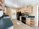 Bright kitchen featuring wood cabinets, black appliances, and tile flooring at 310 E Houston St, Monroe, NC 28112