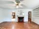 Cozy living room with hardwood floors, fireplace, and view into the kitchen at 310 E Houston St, Monroe, NC 28112