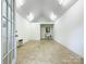 Bright room with white walls, tile floors, utility sink, window, and exterior access at 310 E Houston St, Monroe, NC 28112