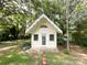 Backyard view of a charming shed with a white door and yellow exterior at 310 E Houston St, Monroe, NC 28112