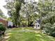 Backyard view featuring a charming shed with a white door and yellow exterior at 310 E Houston St, Monroe, NC 28112