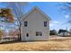 New two-story home featuring light gray siding, a back door, a small backyard, and a well-manicured lawn at 318 Sixth St, Belmont, NC 28012