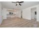 Bright, open-concept living room featuring hardwood floors, ceiling fan, and access to the kitchen at 318 Sixth St, Belmont, NC 28012