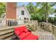 Spacious back deck with wooden stairs, brick chimney, grill, and comfortable red seating area at 360 Lake Landing Dr, Salisbury, NC 28146