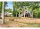Exterior shot of home with deck surrounded by trees and lush landscaping with retaining walls at 360 Lake Landing Dr, Salisbury, NC 28146