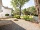 Inviting backyard featuring a fire pit, gravel, a white picket fence, and mature trees creating a cozy outdoor space at 411 Carlisle Dr, Indian Trail, NC 28079