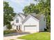 Well-maintained two-story home with white siding, attached garage, and a lush green lawn surrounded by mature trees at 411 Carlisle Dr, Indian Trail, NC 28079