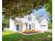 Charming two-story home featuring a bright blue front door, white siding, and a well-manicured front yard at 411 Carlisle Dr, Indian Trail, NC 28079