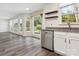 Modern kitchen with hardwood floors, stainless steel dishwasher, and bright windows offering outdoor views at 411 Carlisle Dr, Indian Trail, NC 28079