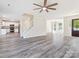 Open-concept living room with gray flooring, connecting kitchen, staircase, and entry door with great lighting at 411 Carlisle Dr, Indian Trail, NC 28079