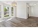 Sunlit living room featuring beautiful hardwood floors, large windows, and a stylish chandelier for a cozy atmosphere at 411 Carlisle Dr, Indian Trail, NC 28079