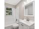 Bathroom featuring tiled shower-tub combination, white vanity, and window at 4413 Tillman Rd, Charlotte, NC 28208