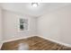 Cozy bedroom with hardwood floors, neutral paint, and a window view at 4413 Tillman Rd, Charlotte, NC 28208