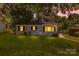 A cozy, single-story home with neat landscaping under the evening sky at 4413 Tillman Rd, Charlotte, NC 28208