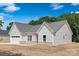 Side angle of a well-maintained single-story home with a two-car garage and gray roof at 4472 Pebblebrook Sw Cir, Concord, NC 28027
