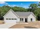 Charming single-story home with a two-car garage, gray roof, and manicured lawn at 4472 Pebblebrook Sw Cir, Concord, NC 28027