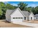 Side angle of a well-maintained single-story home with a two-car garage and gray roof at 4472 Pebblebrook Sw Cir, Concord, NC 28027