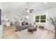 Bright living room with vaulted ceiling, hardwood floors, large window, and modern furnishings at 4472 Pebblebrook Sw Cir, Concord, NC 28027