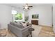 Stylish living room featuring a comfortable gray sofa, hardwood floors, and a large window at 4472 Pebblebrook Sw Cir, Concord, NC 28027
