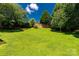 Expansive backyard with lush greenery, mature trees, and a brick retaining wall at 511 Birmingham Ct, Rock Hill, SC 29732