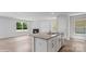 Kitchen island featuring bar seating, a sink, and an adjacent fireplace, all illuminated by natural light at 514 13Th Avenue Ne Dr, Hickory, NC 28601
