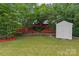 Backyard featuring a storage shed, flowerbeds, and lush trees at 516 Cool Creek Dr, Rock Hill, SC 29732
