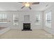 Cozy living room with a fireplace, ceiling fan, and large windows providing ample natural light at 516 Cool Creek Dr, Rock Hill, SC 29732
