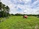 Large backyard features a storage shed with a red roof and lush green grass at 5321 State Line Rd, Marshville, NC 28103