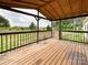 Cozy covered porch with wood flooring and railing, overlooking a serene landscape at 5321 State Line Rd, Marshville, NC 28103
