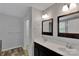 Bathroom featuring double sinks with framed mirrors, dark cabinets and tile flooring at 6000 Boathouse Ln # C, Cramerton, NC 28032