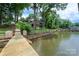 Waterfront property featuring wooden dock, fenced yard, easy access to the water, and a lush treeline at 6259 River Cabin Ln, Charlotte, NC 28278