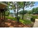 Lush backyard with manicured lawn and fence leads to tranquil lake, framed by mature trees and neighboring docks at 6259 River Cabin Ln, Charlotte, NC 28278