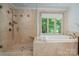 Beautiful bathroom with a glass shower and a tub under a large window with greenery views at 6259 River Cabin Ln, Charlotte, NC 28278