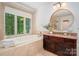Elegant bathroom featuring a large window, a soaking tub, and a granite vanity at 6259 River Cabin Ln, Charlotte, NC 28278