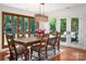 Bright dining room with wood floors, a stylish chandelier, and views of the lush greenery outside at 6259 River Cabin Ln, Charlotte, NC 28278