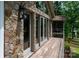Exterior stone wall with doors that open to a wooden balcony with a lake view at 6259 River Cabin Ln, Charlotte, NC 28278