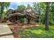 Stunning multi-level home with tiered balconies, screened porch, lush landscaping, and serene outdoor living spaces at 6259 River Cabin Ln, Charlotte, NC 28278